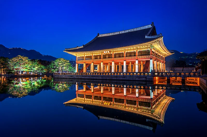 El pabellón Gyeonghoeru del palacio Gyeongbokgung, iluminado de noche y reflejado en el estanque