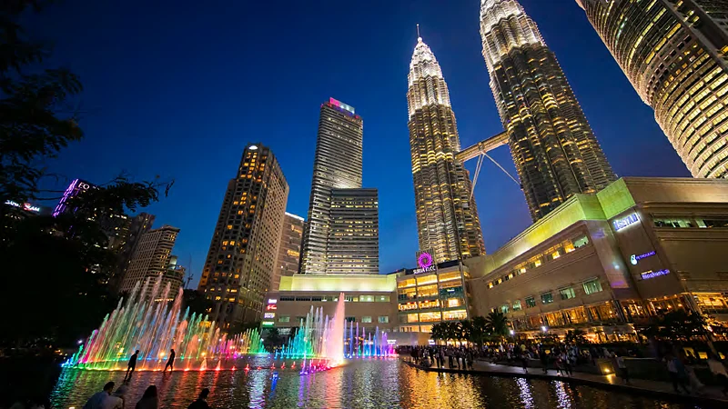 Las torres Petronas iluminadas sobre las fuentes del parque KLCC