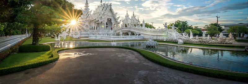 Vista panorámica del Templo Blanco de Chiang Rai con el sol detrás