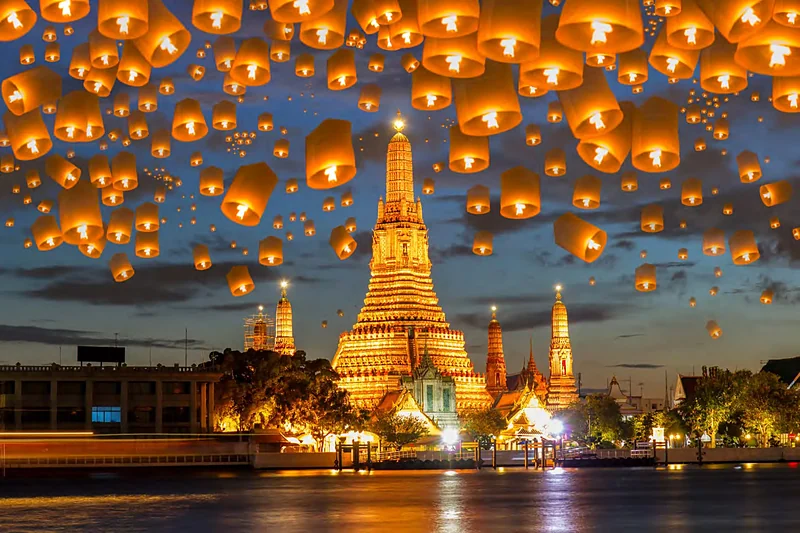 Linternas encendidas flotando de noche sobre el templo Wat Arun, a orillas del río Chao Phraya en Bangkok